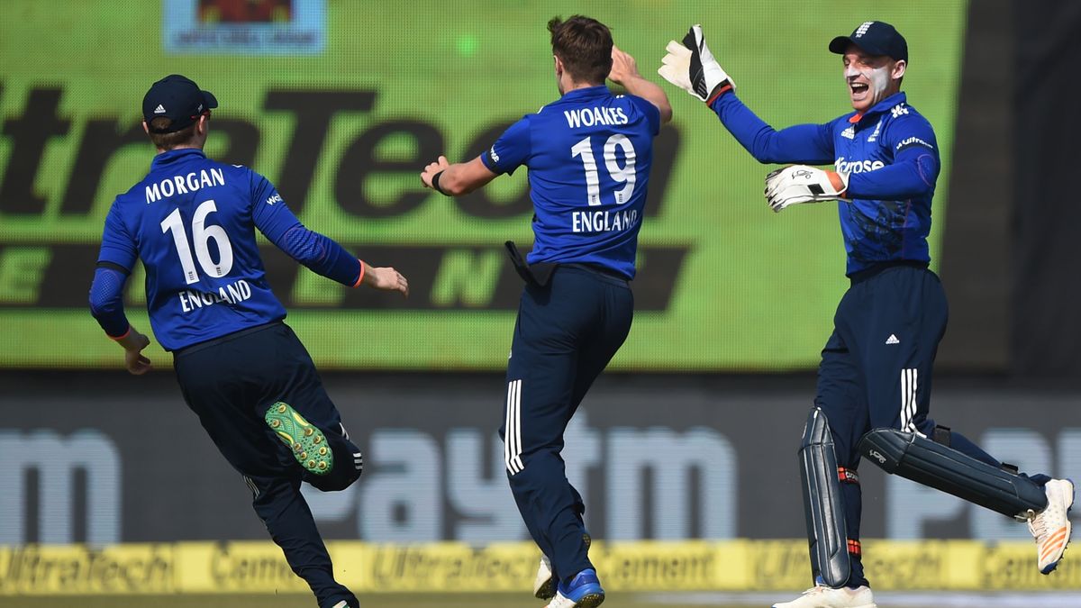 Eoin Morgan, Chris Woakes and Jos Buttler celebrate a wicket on their ODI tour of India